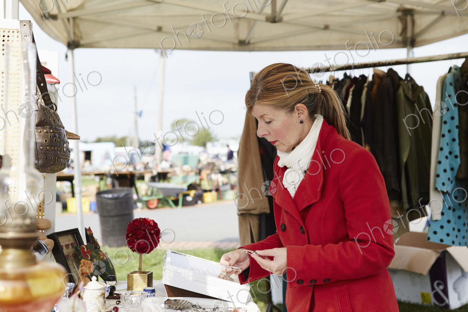 A mature woman bargain hunter browsing through vintage jewellery items