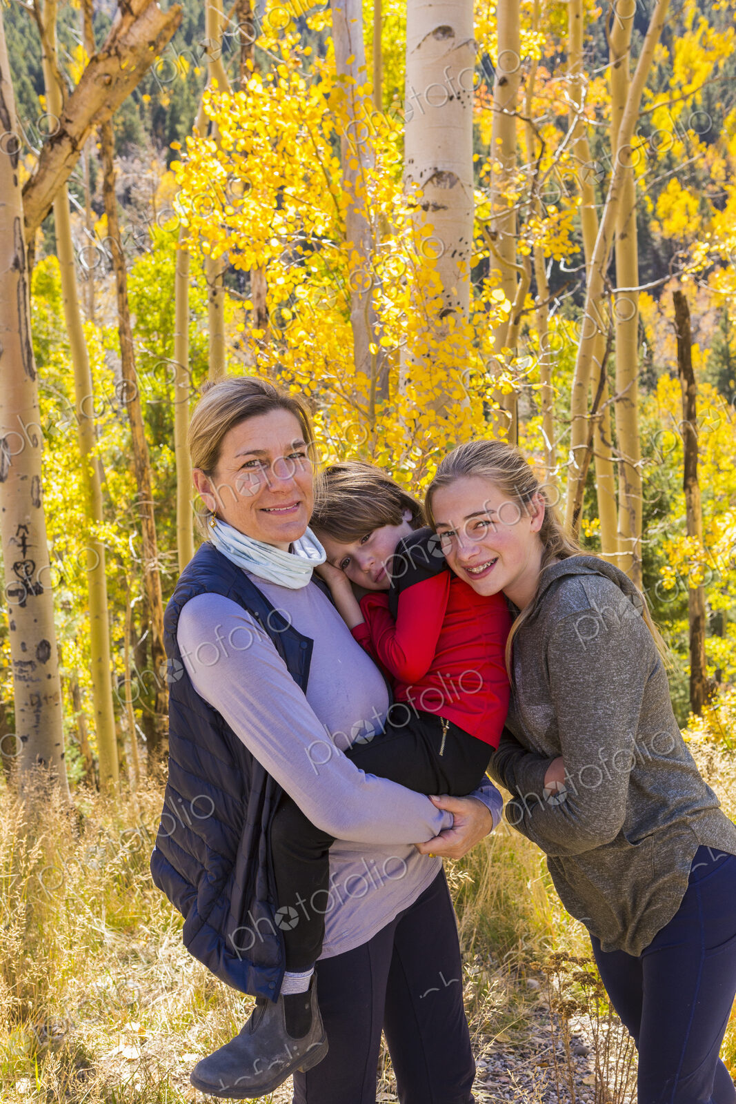 A mature woman, boy and girl, a mother and her two children in woodland, aspen trees…