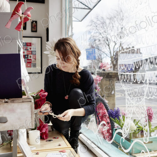 A mature woman in a gift shop holding a small star. A mature woman in a gift shop holding a small star.