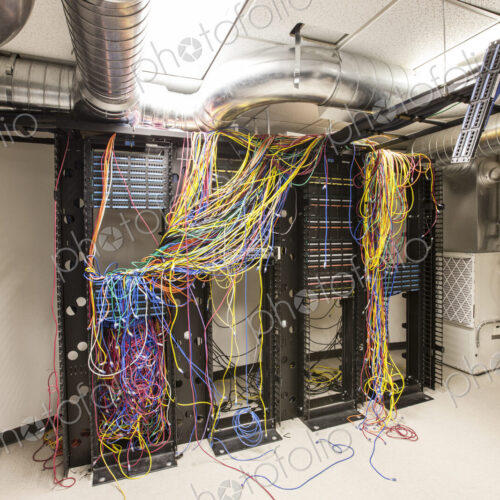A mess of Cat 5 cables in an office server room. A mess of Cat 5 cables in an office server room.