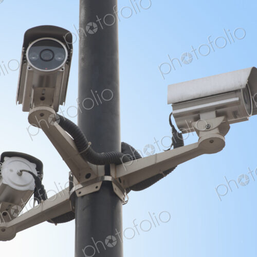 A metal post with a gantry and traffic cameras facing in three different directions… A metal post with a gantry and traffic cameras facing in three different directions…