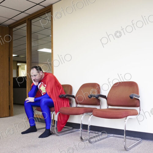 A middle aged caucasisan office super hero ponders the stress of the job. A middle aged caucasisan office super hero ponders the stress of the job.