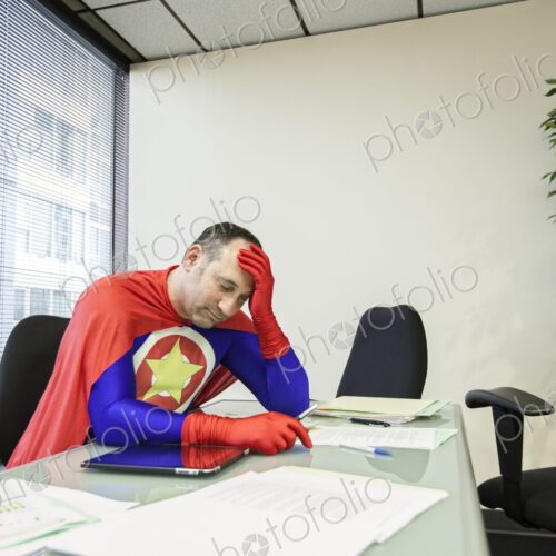 A middle aged caucasisan office super hero ponders the stress of the job. A middle aged caucasisan office super hero ponders the stress of the job.
