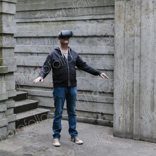 A middle aged man wearing a virtual reality headset. A middle aged man wearing a virtual reality headset.