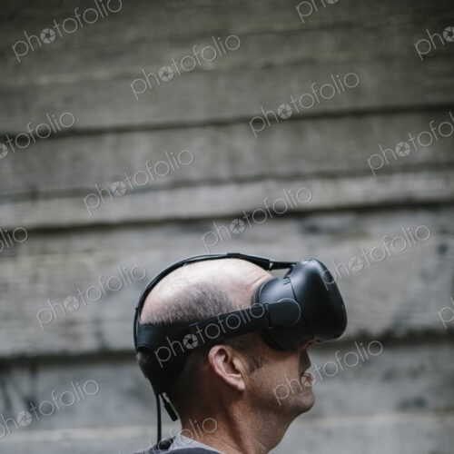 A middle aged man wearing a virtual reality headset. A middle aged man wearing a virtual reality headset.