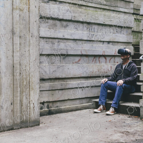 A middle aged man wearing a virtual reality headset. A middle aged man wearing a virtual reality headset.
