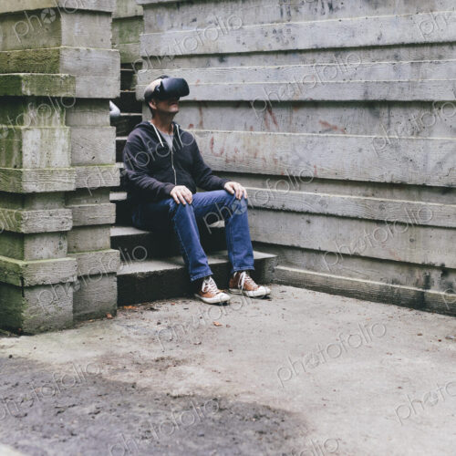 A middle aged man wearing a virtual reality headset. A middle aged man wearing a virtual reality headset.
