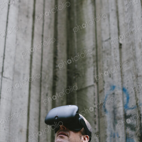 A middle aged man wearing a virtual reality headset. A middle aged man wearing a virtual reality headset.