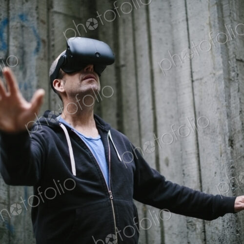A middle aged man wearing a virtual reality headset. A middle aged man wearing a virtual reality headset.