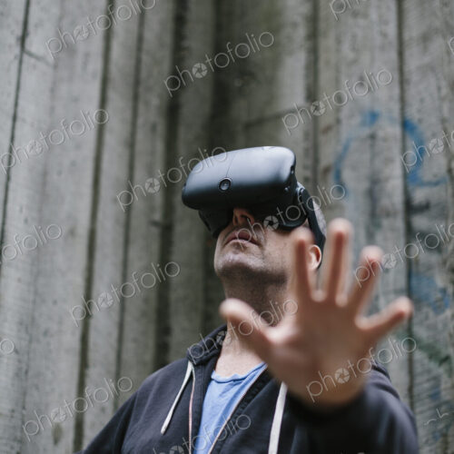 A middle aged man wearing a virtual reality headset. A middle aged man wearing a virtual reality headset.