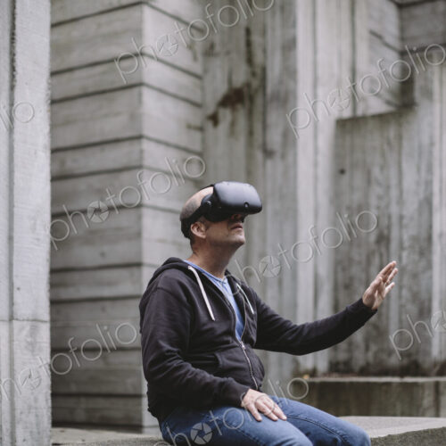 A middle aged man wearing a virtual reality headset. A middle aged man wearing a virtual reality headset.