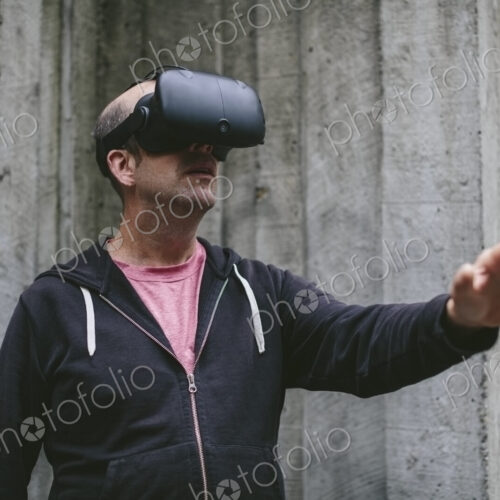 A middle aged man wearing a virtual reality headset. A middle aged man wearing a virtual reality headset.