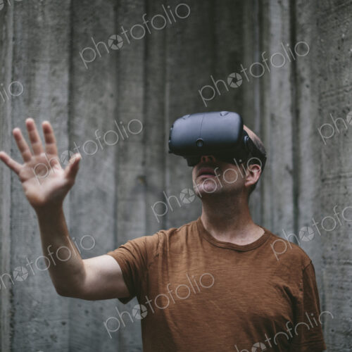 A middle aged man wearing a virtual reality headset. A middle aged man wearing a virtual reality headset.