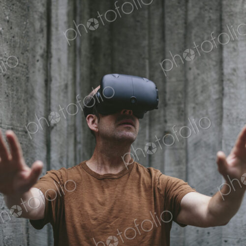A middle aged man wearing a virtual reality headset. A middle aged man wearing a virtual reality headset.