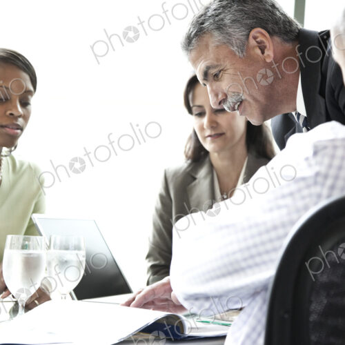 A middle eastern businessman leading a meeting of mixed race business people. A middle eastern businessman leading a meeting of mixed race business people.