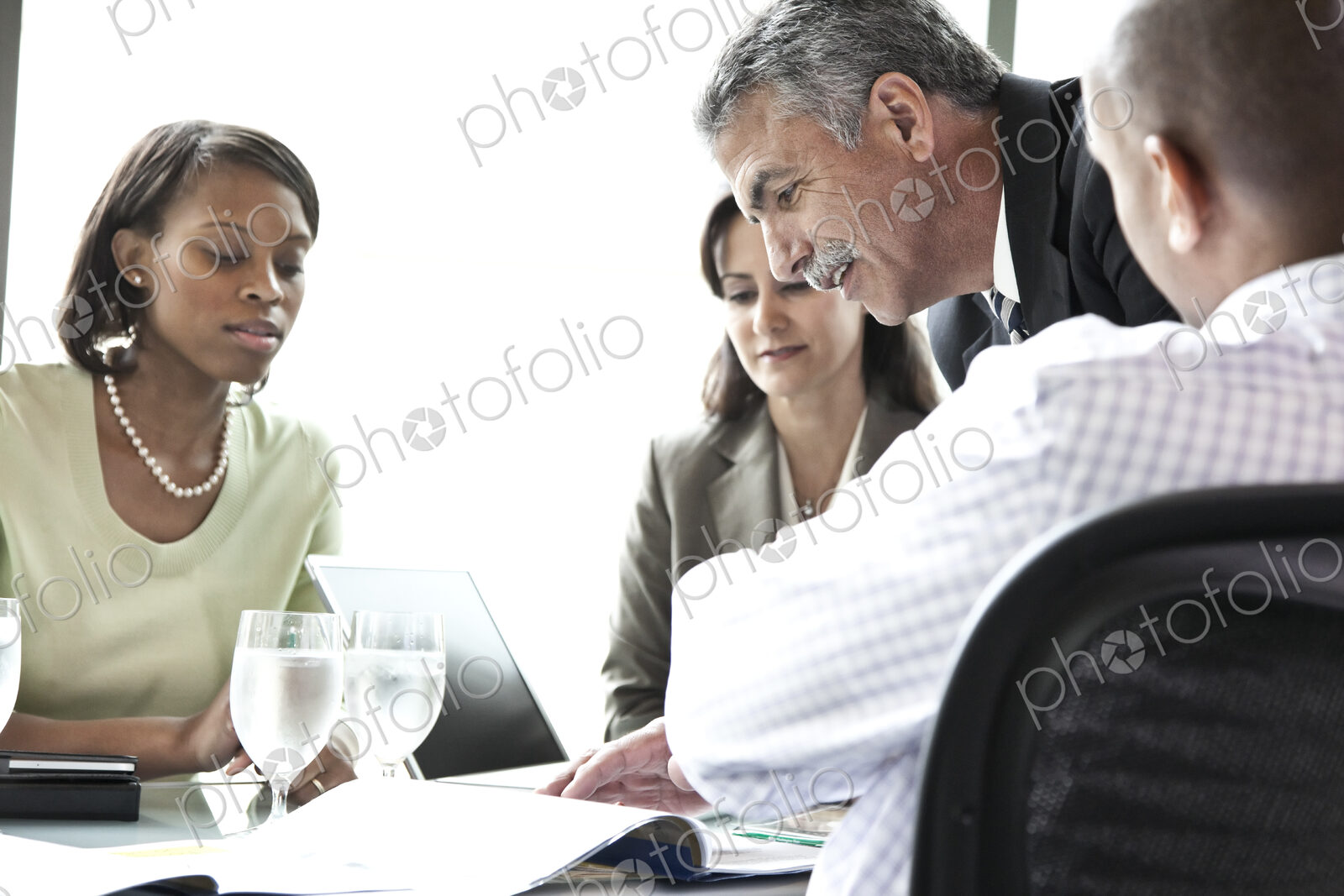 A middle eastern businessman leading a meeting of mixed race business people.