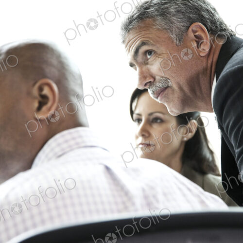 A middle eastern businessman listens to a conversation in a business meeting. A middle eastern businessman listens to a conversation in a business meeting.