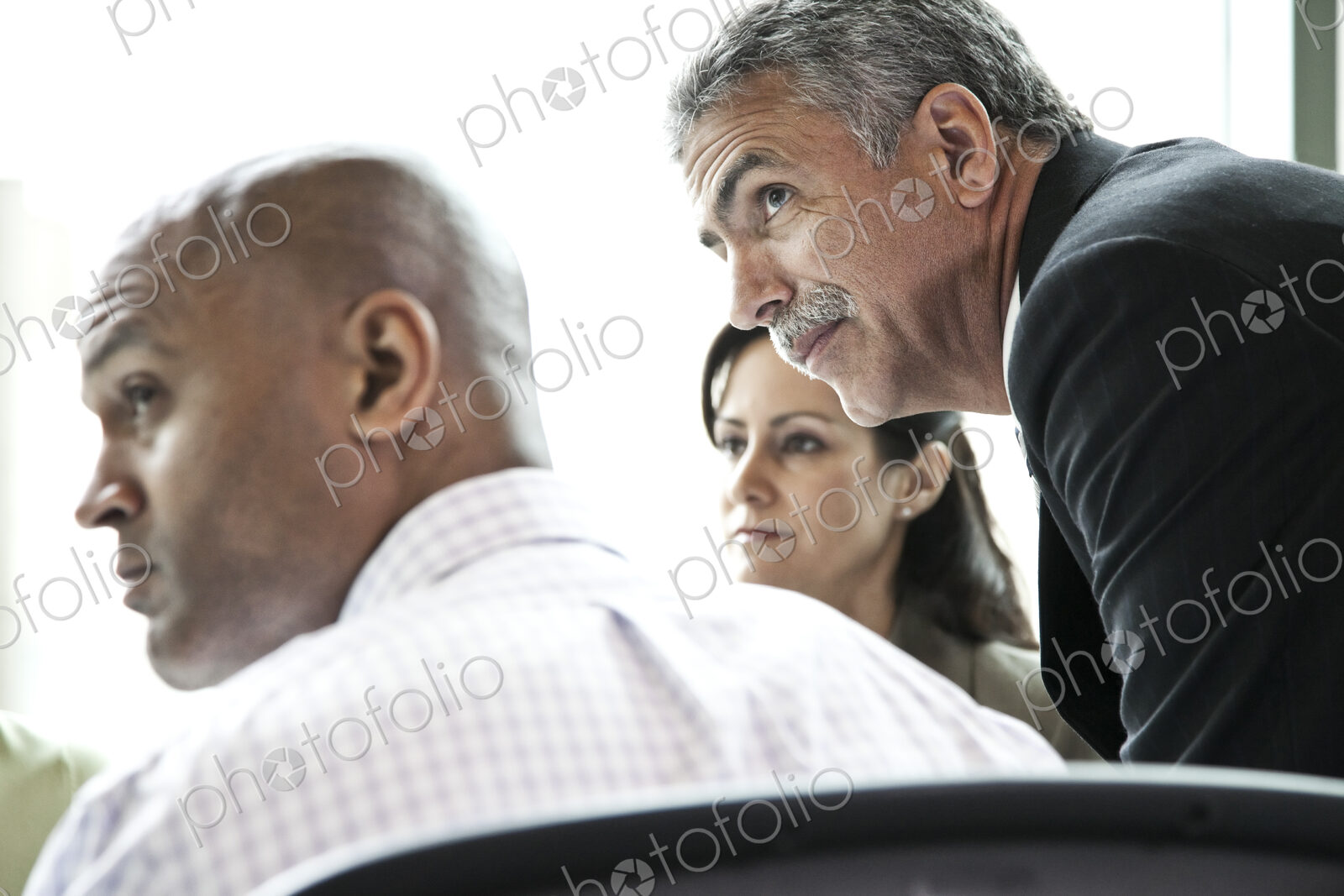 A middle eastern businessman listens to a conversation in a business meeting.