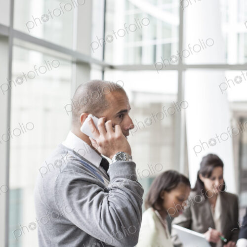 A middle eastern businessman on the phone during a meeting.