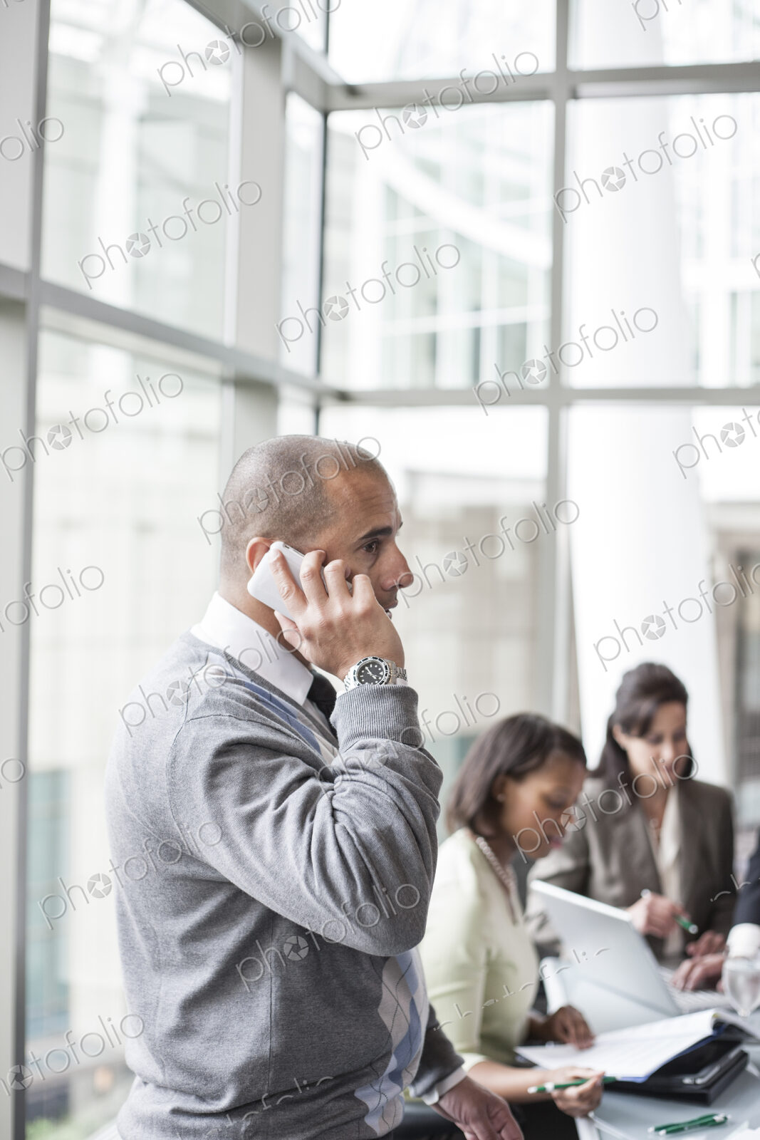 A middle eastern businessman on the phone during a meeting.