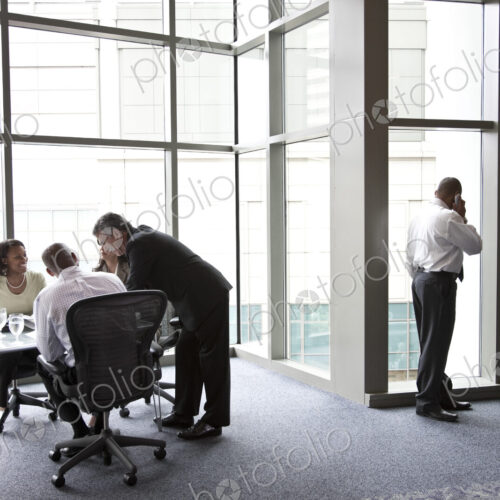 A middle eastern businessman on the phone during a meeting.