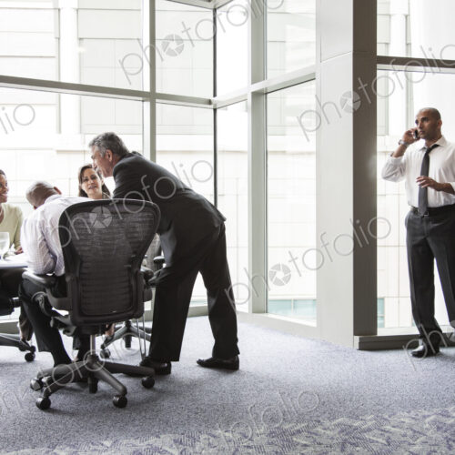 A middle eastern businessman on the phone during a meeting.