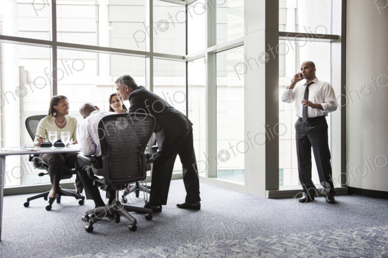 A middle eastern businessman on the phone during a meeting.