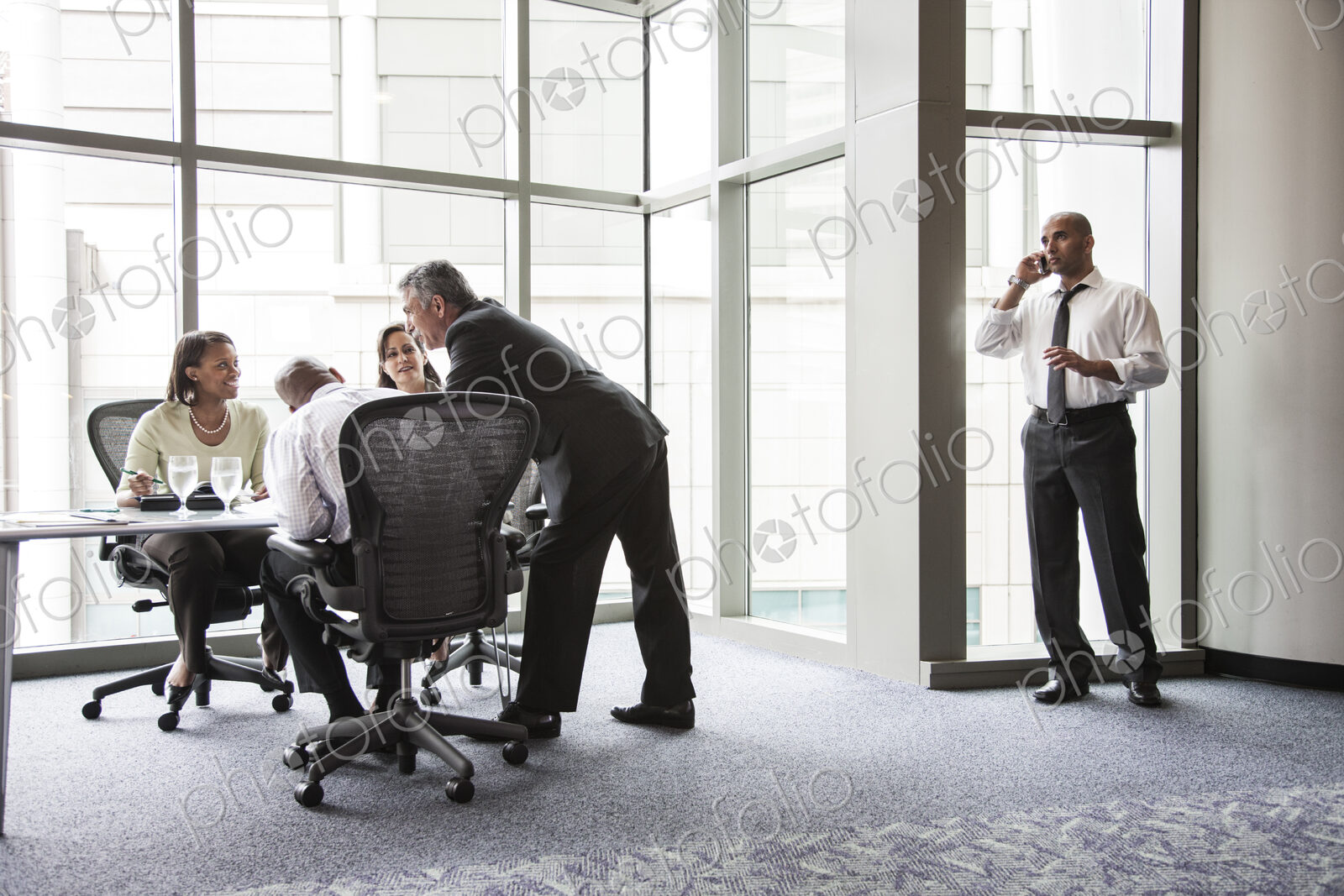 A middle eastern businessman on the phone during a meeting.