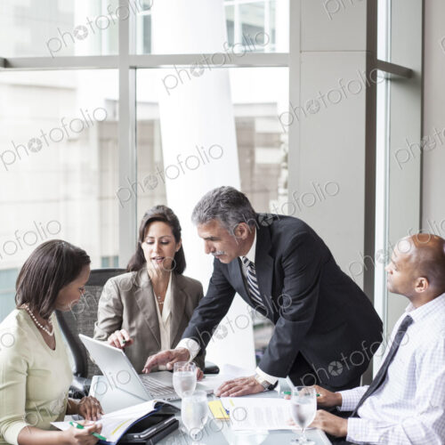 A mixed race group of male and female business people in a meeting at a conference… A mixed race group of male and female business people in a meeting at a conference…