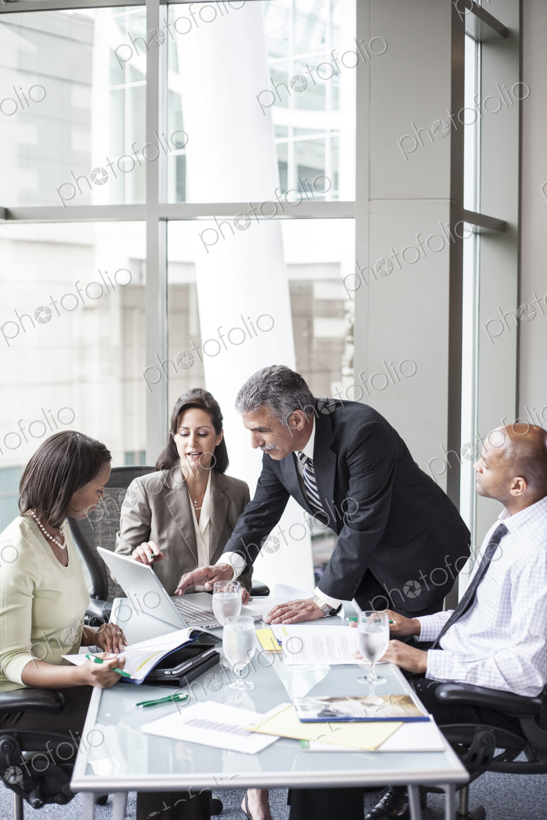 A mixed race group of male and female business people in a meeting at a conference…