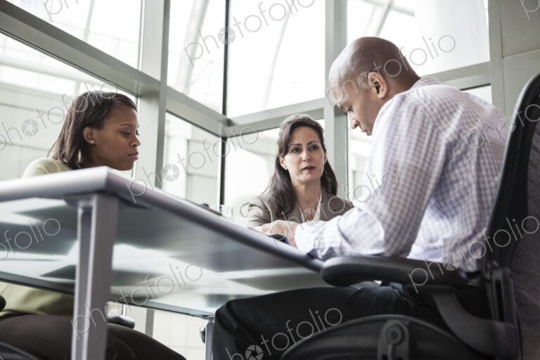 A mixed race group of male and female business people in a meeting at a conference…
