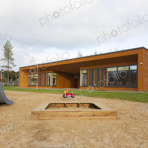 A modern building, nursery or pre-school, a large sand pit play area with a slide. A modern building, nursery or pre-school, a large sand pit play area with a slide.