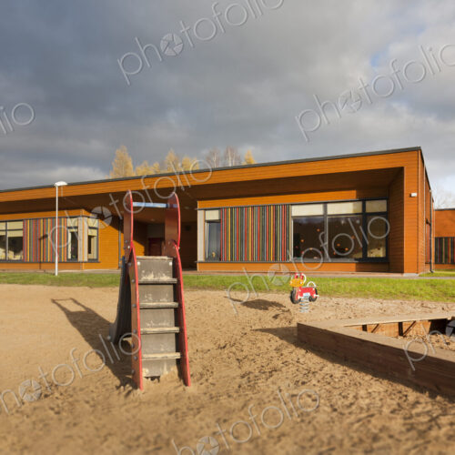 A modern building, nursery or pre-school, a large sand pit play area with a slide. A modern building, nursery or pre-school, a large sand pit play area with a slide.