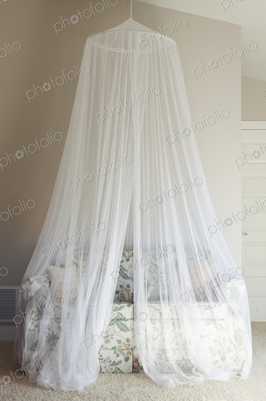 A mosquito net draped over a sofa.