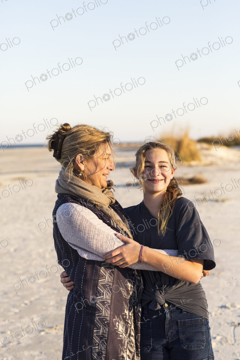 A mother and daughter embracing on a beach