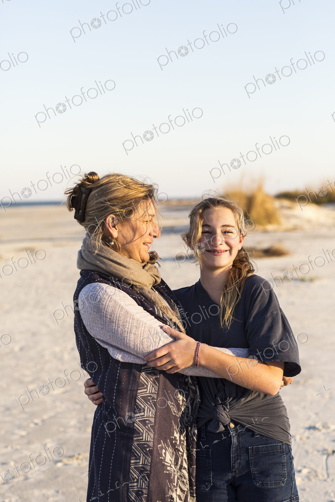 A mother and daughter embracing on a beach