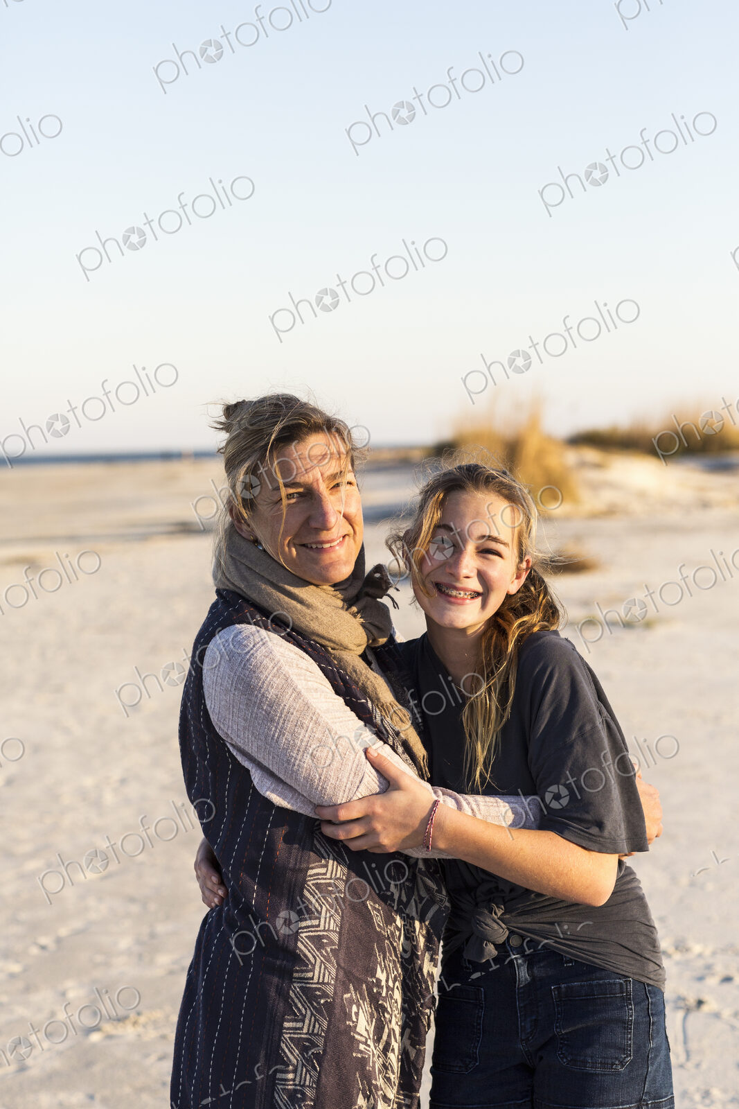 A mother and daughter embracing on a beach