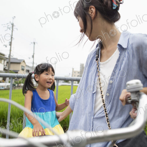 A mother and daughter with a bicycle.
