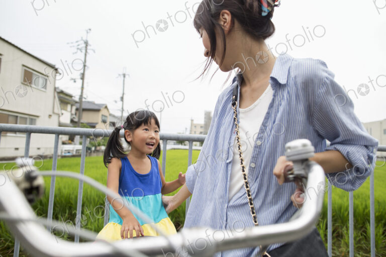 A mother and daughter with a bicycle.