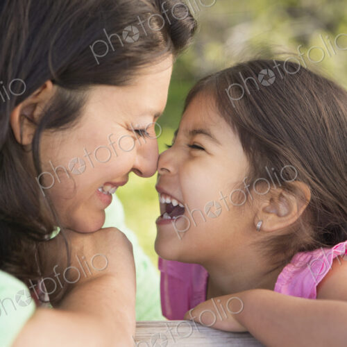 A mother in the park with her daughter, laughing and kissing each other. A mother in the park with her daughter, laughing and kissing each other.