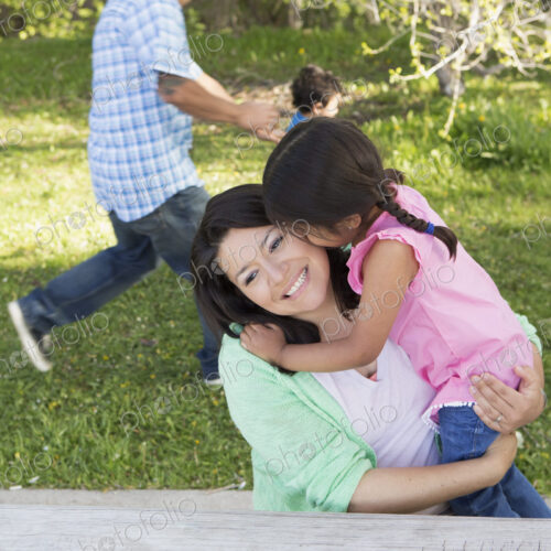 A mother in the park with her daughter, laughing and kissing each other. Father and… A mother in the park with her daughter, laughing and kissing each other. Father and…