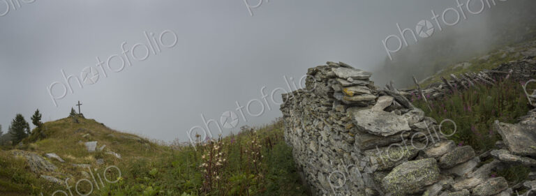 A mountain shrine by the path in the Alpine region near Mont Blanc, a cross near…