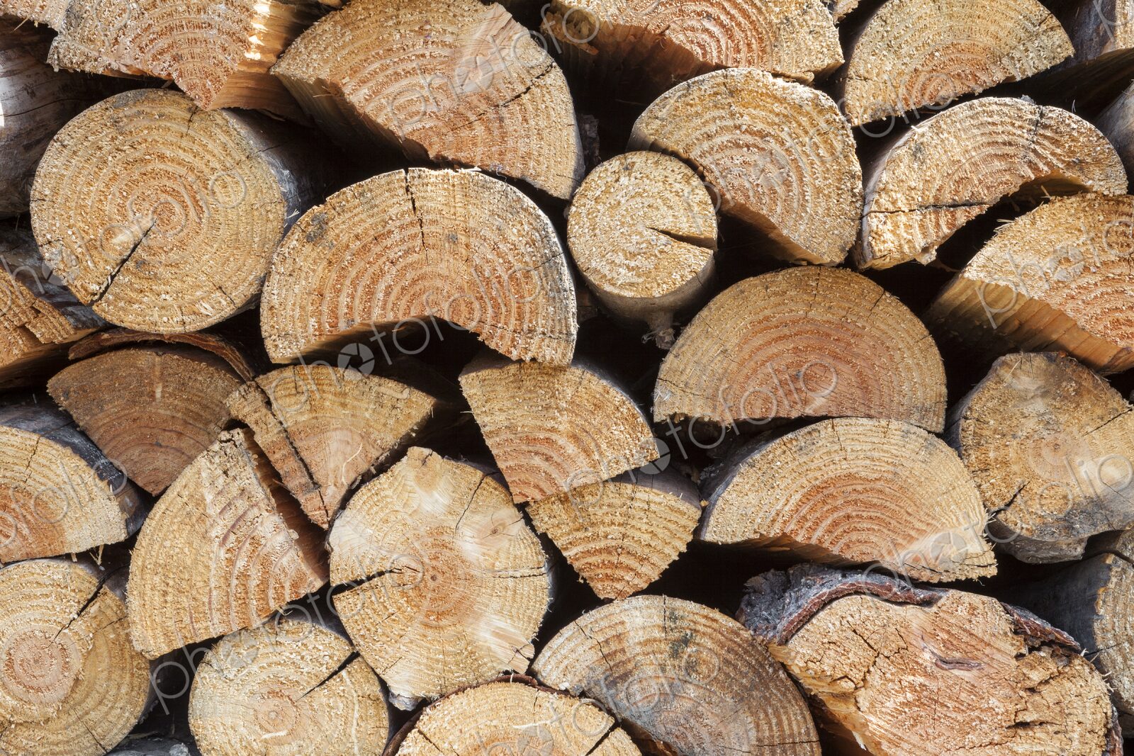 A neatly stacked pile of cut firewood showcases the natural texture and pattern of…