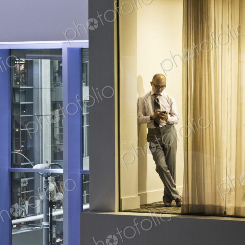 A night view looking into a conference room with an asisan businessman working on his… A night view looking into a conference room with an asisan businessman working on his…