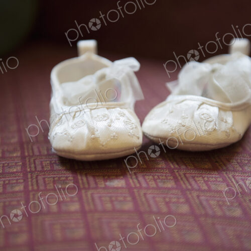 A pair of cream-coloured embroidered satin Christening boots with lace ribbon bows. A pair of cream-coloured embroidered satin Christening boots with lace ribbon bows.