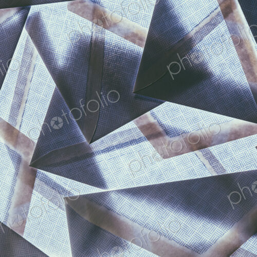 A pattern made by laying and overlapping security envelopes above a lightsource.