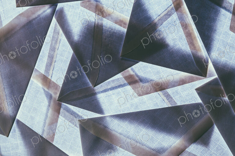 A pattern made by laying and overlapping security envelopes above a lightsource.