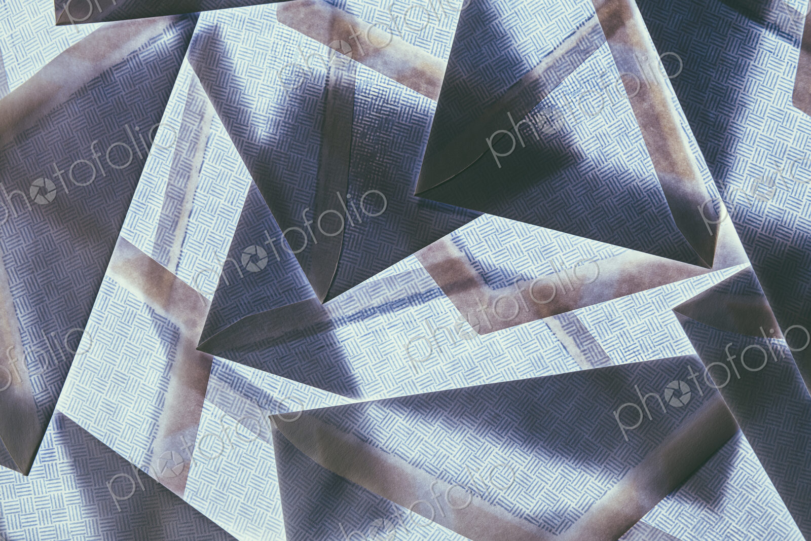 A pattern made by laying and overlapping security envelopes above a lightsource.