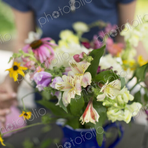 A person arranging a bunch of flowers in a vase. A person arranging a bunch of flowers in a vase.