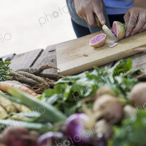 A person chopping freshly picked vegetables and fruits. A person chopping freshly picked vegetables and fruits.
